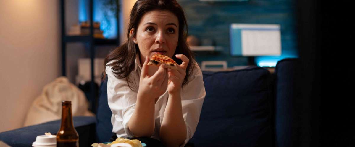 kobieta jedząca pizzę w nocy - nocne podjadanie